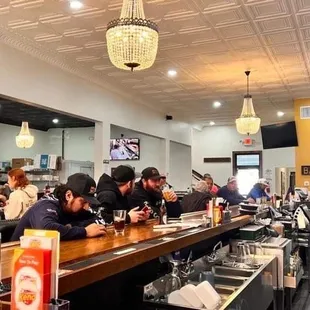 people sitting at the bar of a restaurant