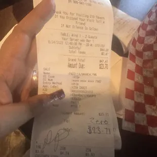 a person's hand holding a receipt