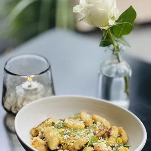 Our light &amp; fluffy Potato Gnocchi, served with corn, basil, snap peas, white wine, and pecorino romano.