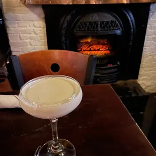 a cocktail in front of a fireplace