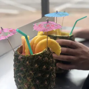 two pineapples with cocktail umbrellas