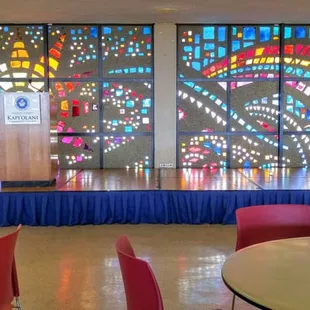 A colorful mosaic serves as a backdrop for the stage area