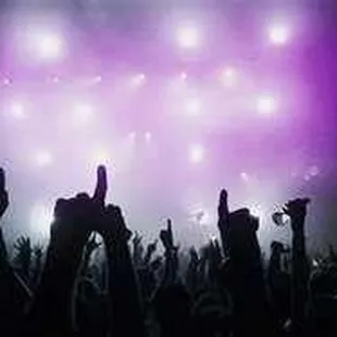 a crowd of people raising their hands in the air