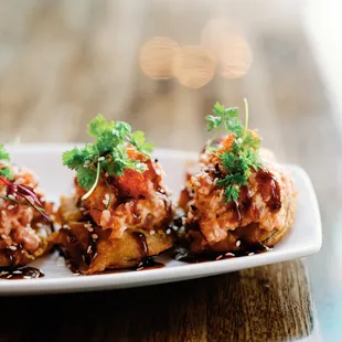 Spicy tuna on fried eggplant served with sweet soy, tobiko, sesame seeds