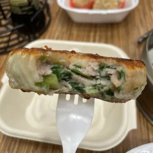 a person holding a piece of food on a fork