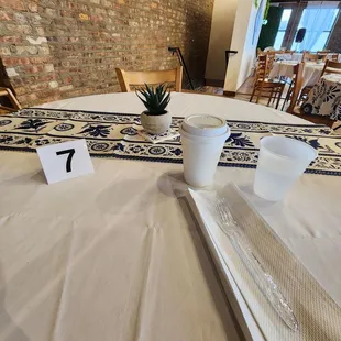 a table setting with place cards and cups