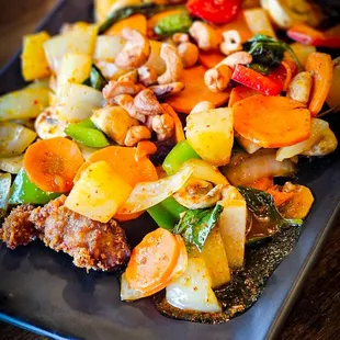 a plate of stir fried chicken with vegetables