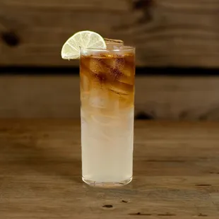 a tall glass of iced tea with a slice of lime