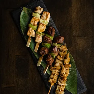 skewered meat and vegetables on a black plate