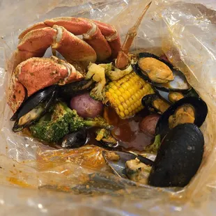 Seafood boil bag with black mussels and dungeness crab