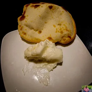 a piece of bread and some cream on a plate