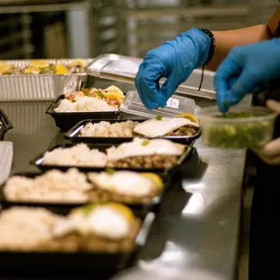 a person in blue gloves preparing food