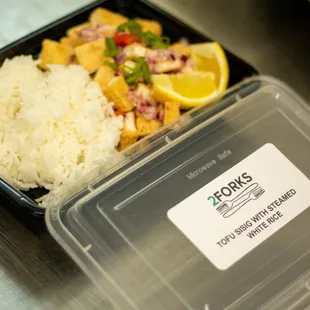 a plastic container with rice and vegetables