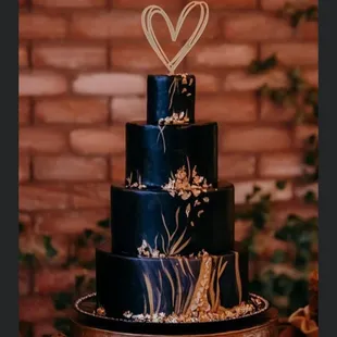 a three tiered cake with a heart topper