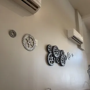 a wall with clocks and air conditioners