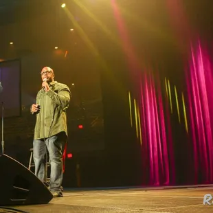 a man on stage speaking into a microphone
