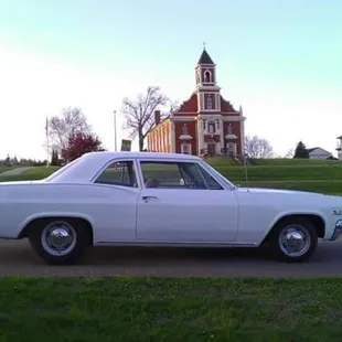 a white car parked in front of a church
