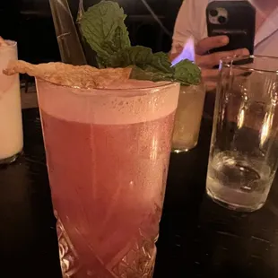 a pink drink with a garnish of mint