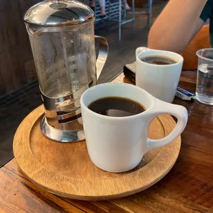 two cups of coffee on a wooden tray