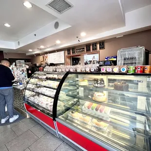 a woman standing in front of a bakery counter