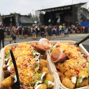 ows two trays of food at a festival
