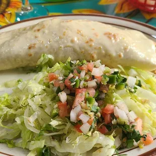 Wet Burrito with rice, shrimp and chicken smothered in white cheese served with guacamole salad. Excellent!