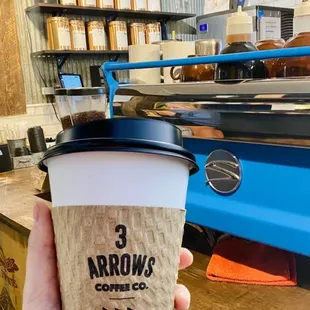 a hand holding a cup of coffee