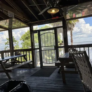 a view of a porch with picnic tables