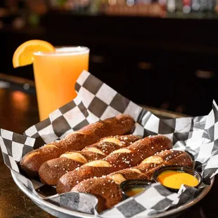 a basket of pretzels and a glass of orange juice