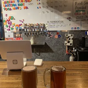 two mugs of beer on a bar