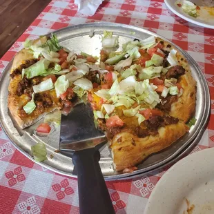 a pizza on a pizza pan with a pizza cutter