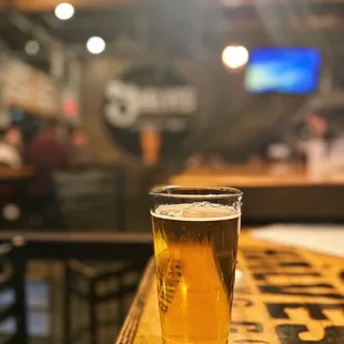 a pint of beer on a bar