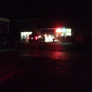 The complete darkness makes the lights from the lotto signs in the gas station brighter than they were. 3 olives is on the left.