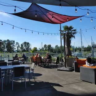 a group of people sitting at tables under umbrellas