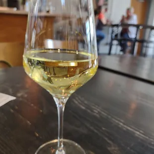 a glass of white wine on a table