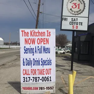 a sign for the kitchen now open serving a full menu and daily drink specials