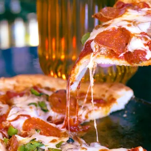 a slice of pepperoni pizza being served