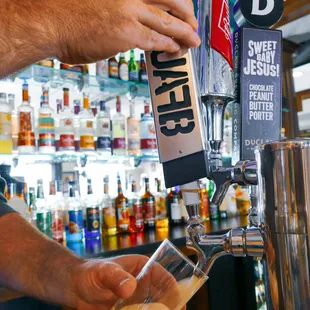 a man pouring a beer at a bar