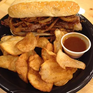 Tender smoked brisket with our sweet homemade brisket sauce and crunchy onion tanglers make a perfect sandwich.