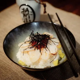 a bowl of food with chopsticks