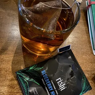 a glass of tea and a packet of tea