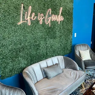 a living room with couches and a green wall