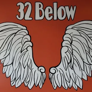an orange sign with white wings