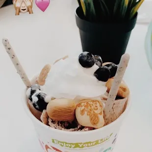 a cup of ice cream with blueberries and cookies