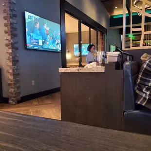 a man sitting at a bar watching tv