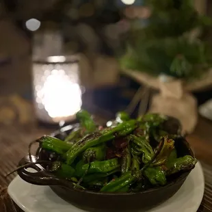 a bowl of green peppers on a table