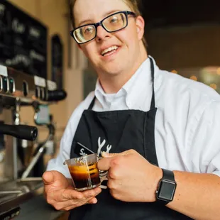 Sam proudly holding a freshly brewed shot of espresso.