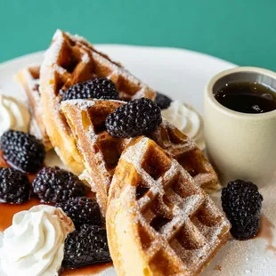 a waffle with whipped cream and blackberries