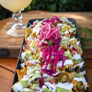 a platter of nachos and a margarita