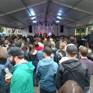 a large group of people standing under a tent
